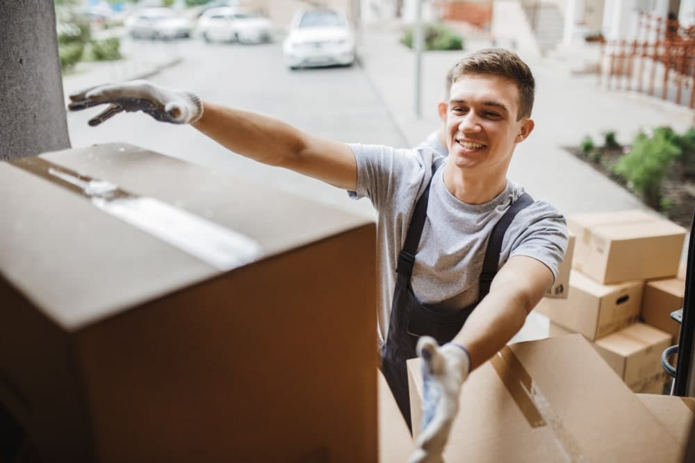 Mover unloading boxes from a van for a house move